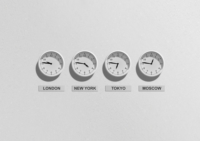 Biele hodinky na stene s časmi v Tokiu, New Yourku, Moskve a Londýne